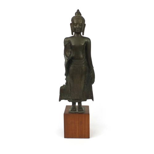 605 - Antique Thai patinated bronze standing figure of Buddha, on a later wooden stand, overall 61cm high