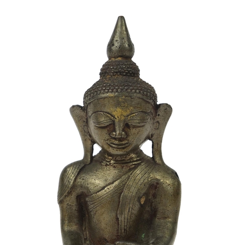 604 - Antique Thai patinated bronze seated figure of Buddha, script to the reverse, 18.5cm high