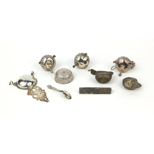 614 - Predominately Burmese silver coloured metal items including three piece cruet, strainer, triangular ... 