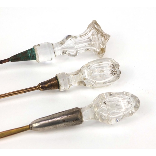 107 - Three glass handled ear scoops each with brass scoop, the largest 16.5cm in length