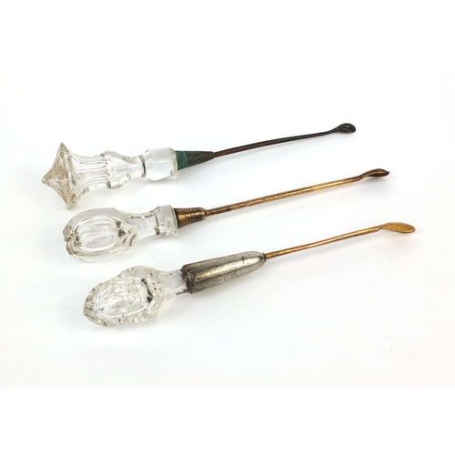 107 - Three glass handled ear scoops each with brass scoop, the largest 16.5cm in length