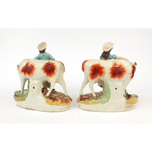 693 - Pair of Victorian Staffordshire pottery cows with milk maid and herdsman, the largest 26cm high