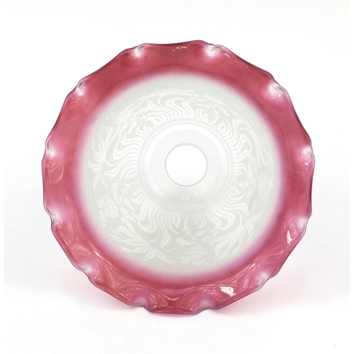 699 - Cranberry and clear glass shade etched with stylised flowers, 19cm high