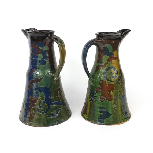 772 - Pair of French art pottery ewers, incised and hand painted with floral motifs, the largest 29cm high