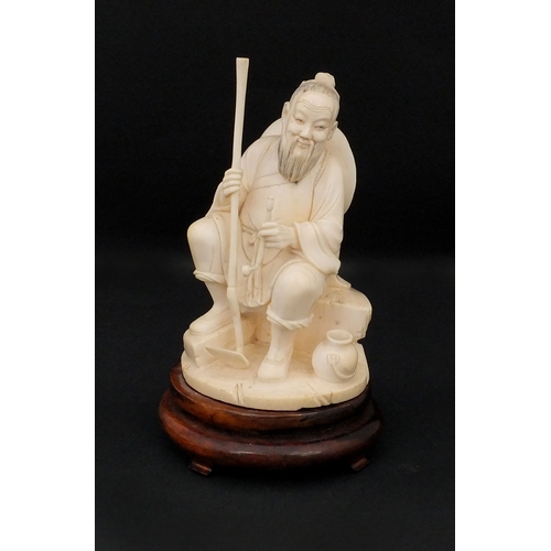 546 - Japanese carved ivory okimono, of a seated elder holding a pipe, raised on a wooden base, character ... 