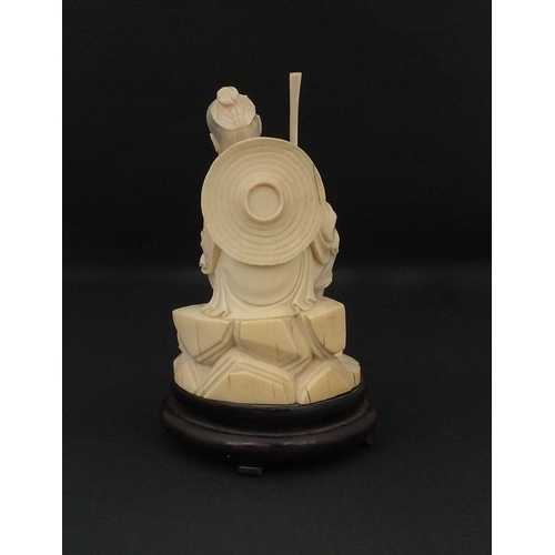 546 - Japanese carved ivory okimono, of a seated elder holding a pipe, raised on a wooden base, character ... 