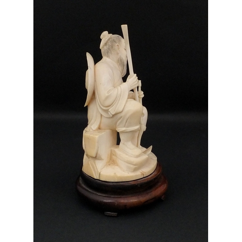 546 - Japanese carved ivory okimono, of a seated elder holding a pipe, raised on a wooden base, character ... 