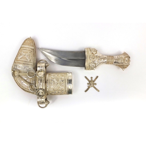 621 - Omani Khanjar dagger with unmarked silver mounted handle and sheath, housed in a display case, the d... 