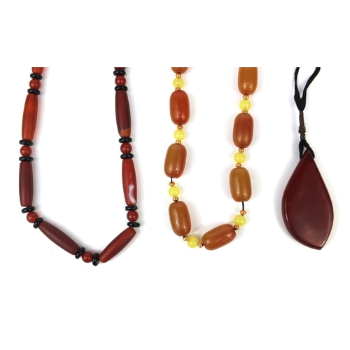 361 - Assorted jewellery comprising an amber coloured necklace, red glass bead necklace and a pendant