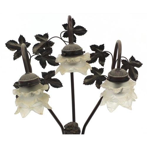 181 - Bronze style figural table lamp with floral frosted glass shades, 82cm high