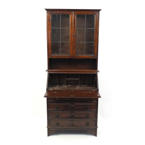 150 - Carved oak bureau bookcase fitted with a pair of leaded glass doors above a fall and four drawers, 1... 