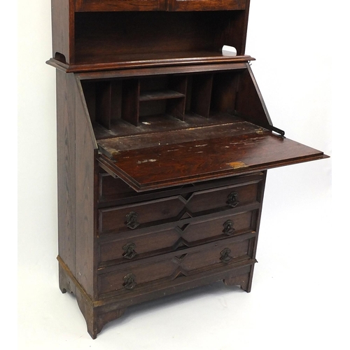 150 - Carved oak bureau bookcase fitted with a pair of leaded glass doors above a fall and four drawers, 1... 