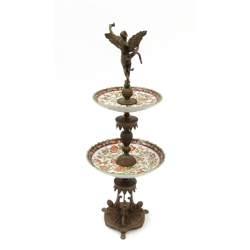 2049 - Bronzed and ceramic two tier centre piece modelled as a winging figure, with stylised column and bas... 