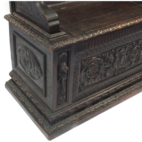 2009 - Profusely carved oak monks bench with lion handles and lift up seat, 112cm high x 105cm wide x 48cm ... 