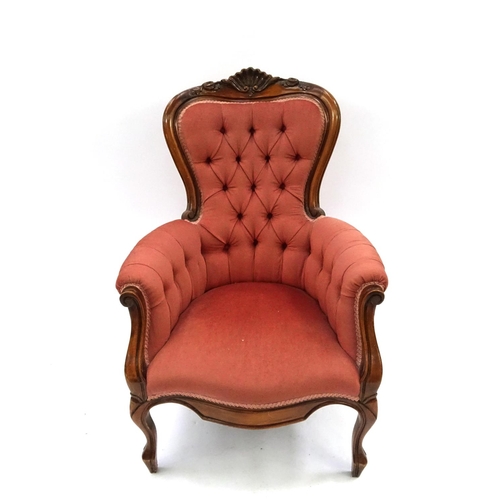 2042 - Victorian style walnut framed reading chair with shell crest and salmon button back upholstery, 103c... 