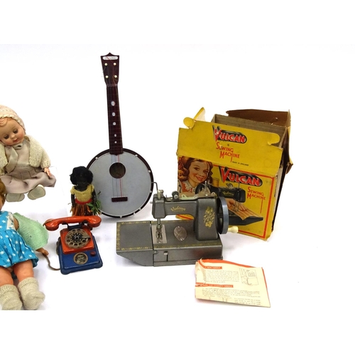 554 - Vintage toys including a boxed Vulcan sewing machine, tin plate telephone, dolls and a Selcol banjo