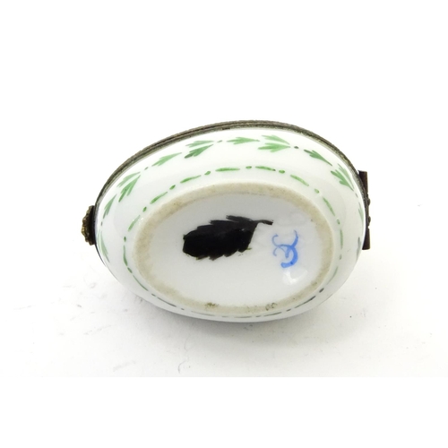 427 - French enamelled porcelain egg trinket, the hinged lid decorated with a hot air balloon, 6cm long