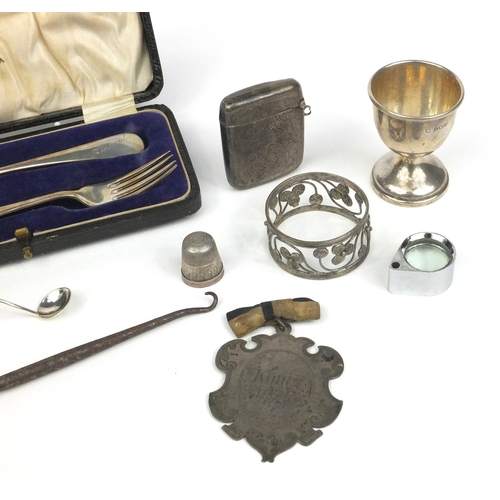 394 - Silver items including a boxed christening fork and spoon, vesta, thimble, egg cup etc, various hall... 