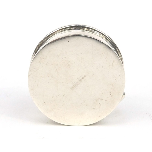 399 - Circular silver pill box, the hinged lid with  marcasite and blue stones, 3cm in diameter