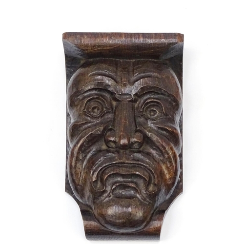 459 - Carved wooden grotesque face wall bracket and a carved wooden panel of a knights helmet