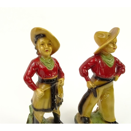 674 - Pair of painted plaster cowboy and cowgirl figures, 33cm high