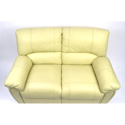 16 - Cream leather reclining two seater settee, 140cm long