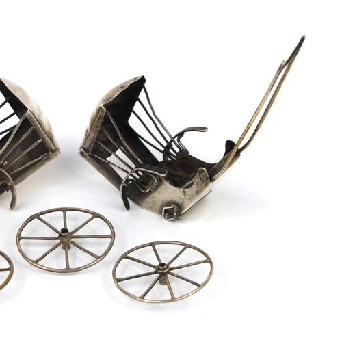 2293 - Two Chinese silver rickshaw one with impressed marks to the reverse, each 8cm in length, approximate... 