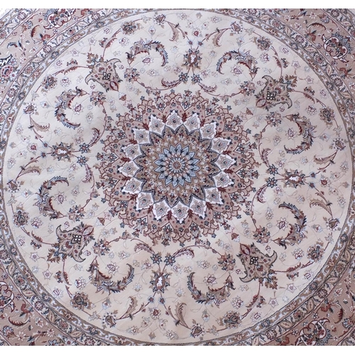 2025 - Circular Persian rug having all over floral motifs of a predominately beige ground with label to rev... 