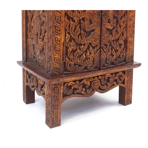 2043 - Indonesian hardwood side cabinet fitted with a pair of doors, carved with foliage, 56.5cm high x 39c... 