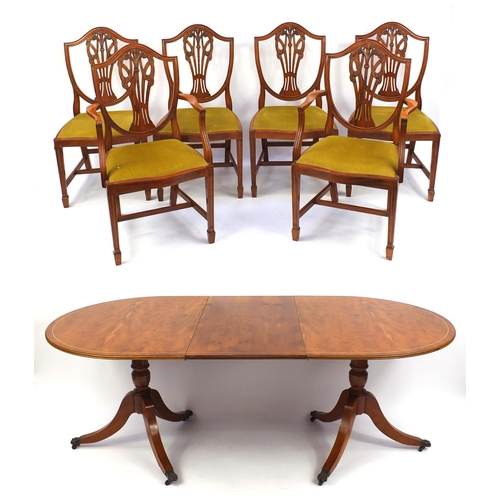 9 - Yew twin pedestal D-end dining and six dining chairs including two carvers, each carved with The Pri... 