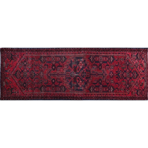 15 - Rectangular Hamadan carpet runner with an all over geometric and floral design onto a red ground, 25... 