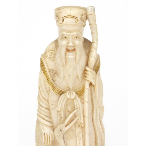 547 - Japanese carved ivory okimno of an elder with a crane, standing upon a tortoise, 17cm high