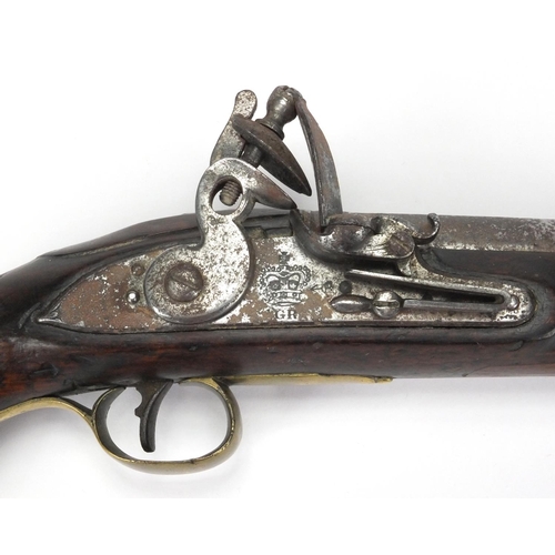 357 - Antique flint lock pistol with brass mounts, engraved Tower, GR emblem and proof marks, initialled T... 