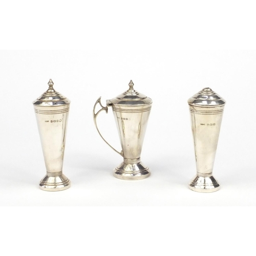 825 - Silver three piece cruet of cylindrical tapering form, A.L.D Birmingham 1935, the largest 10cm high,... 