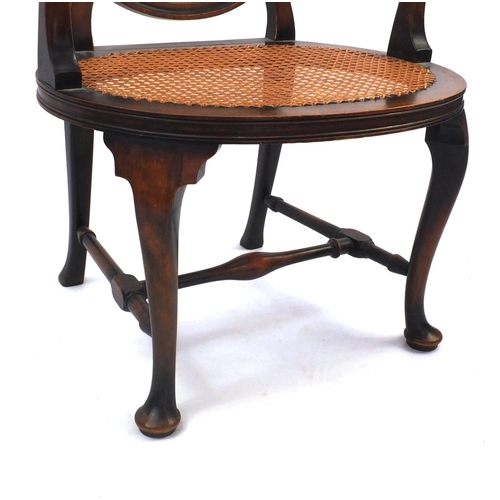 2055 - Stained beech elbow chair, the circular cane back with star motif and cane and seat, the back with s... 