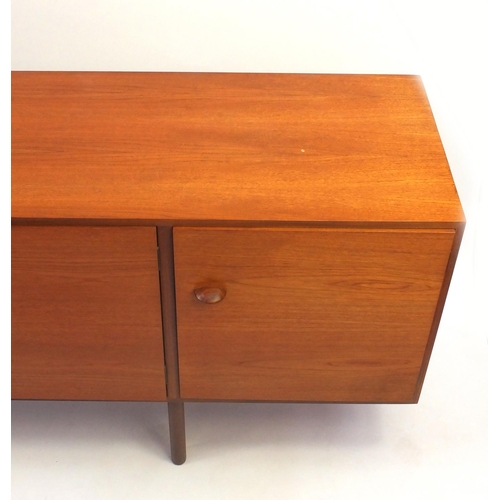 2021 - 1970's teak sideboard fitted with three cupboard doors and four graduated drawers, 77cm high x 199cm... 