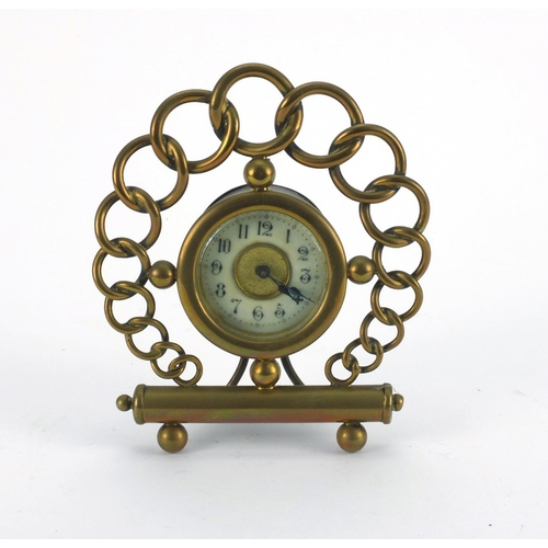 2256 - Brass chain link strut clock with enamelled dial and Arabic numerals, 15cm high