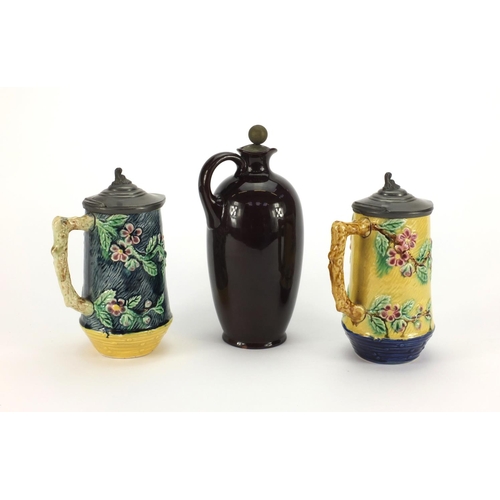 2343 - Doulton Tony Weller whisky flask together with two Victorian Majolica jugs both with pewter lids, th... 