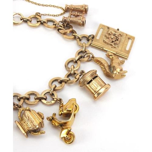 907 - 9ct gold charm bracelet with a selection of mostly gold charms including a squirrel, passport, binoc... 