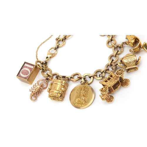 907 - 9ct gold charm bracelet with a selection of mostly gold charms including a squirrel, passport, binoc... 