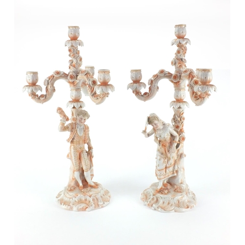 662 - Pair of 19th century continental porcelain three branch candelabras, one modelled with a young male ... 