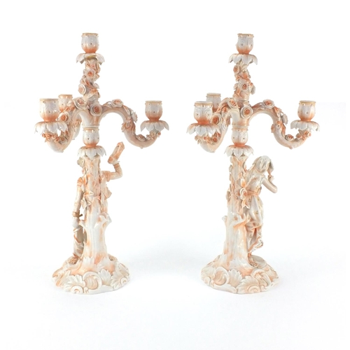 662 - Pair of 19th century continental porcelain three branch candelabras, one modelled with a young male ... 