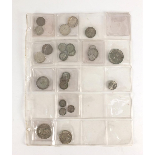 212 - Queen Anne and later predominantly British coinage, some silver housed in a folder including a 1711 ... 