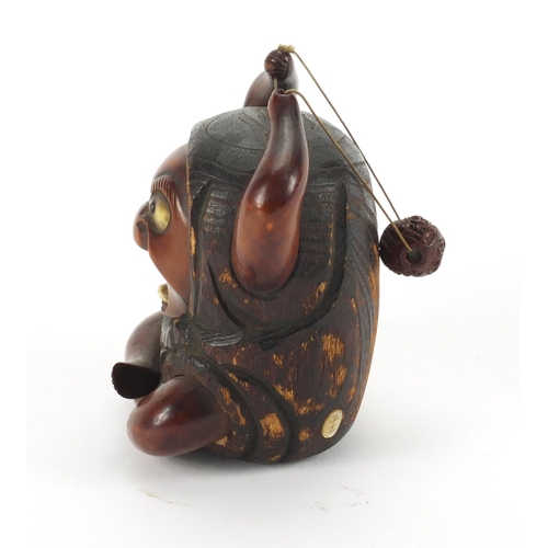 565 - Japanese wooden devil with bone eyes and tongue, inset Mother of Pearl panel with character marks to... 