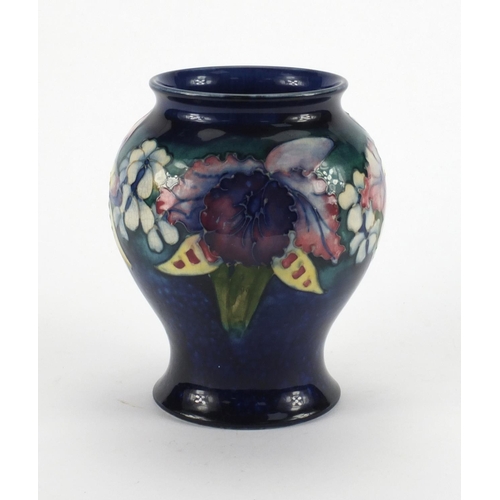 712 - Moorcroft Orchid pattern baluster vase, onto a blue ground, factory marks to the base, 15.5cm high