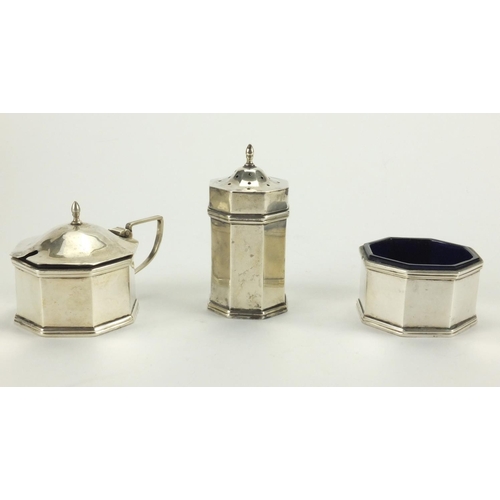 821 - Art Deco octagonal silver three piece cruet with blue glass liners, housed in a fitted case, W.M.CO ... 