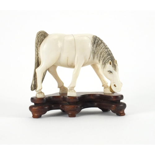 549 - Chinese carved ivory study of a horse raised on a hardwood base, overall 10cm high