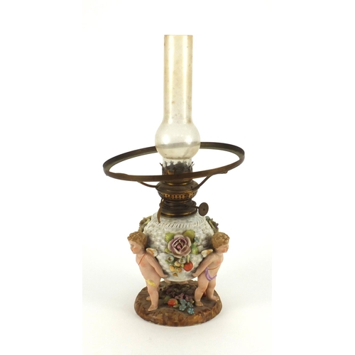 664 - Continental hand painted porcelain oil lamp base with putti supports, overall 40cm high