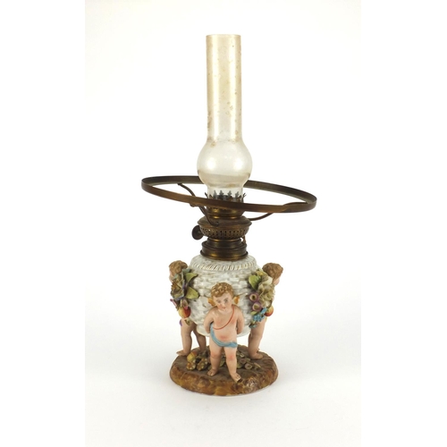 664 - Continental hand painted porcelain oil lamp base with putti supports, overall 40cm high