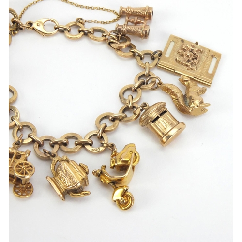 907 - 9ct gold charm bracelet with a selection of mostly gold charms including a squirrel, passport, binoc... 